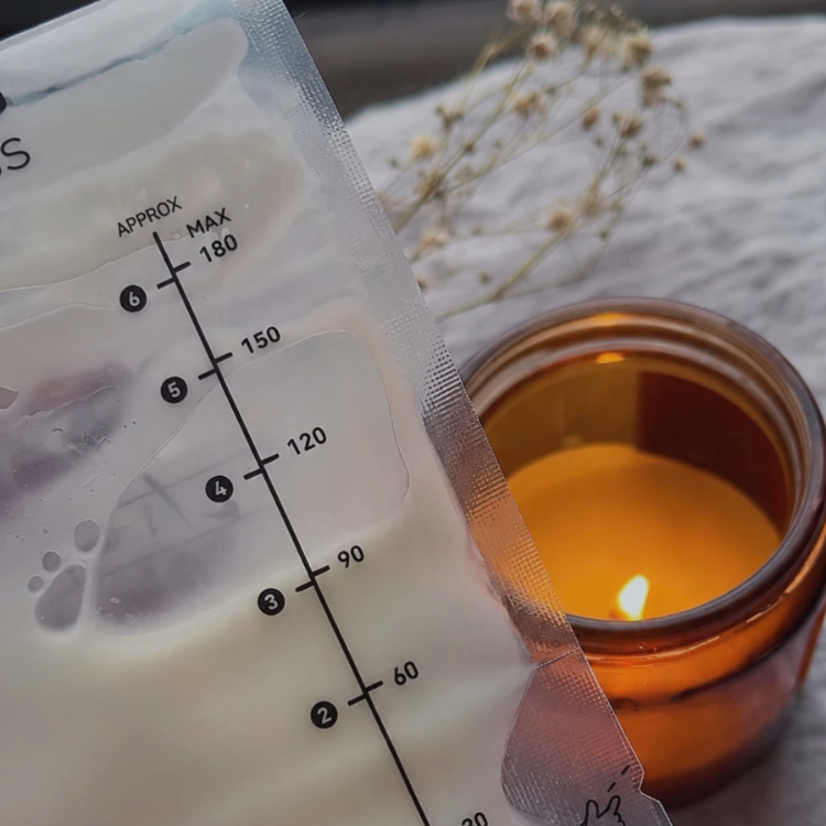 a bag of breast milk with a lit candle in the background
