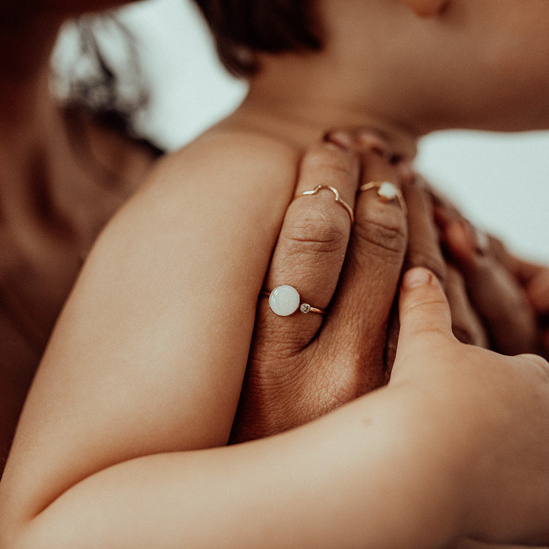 women holding a baby, with rings on her fingers
