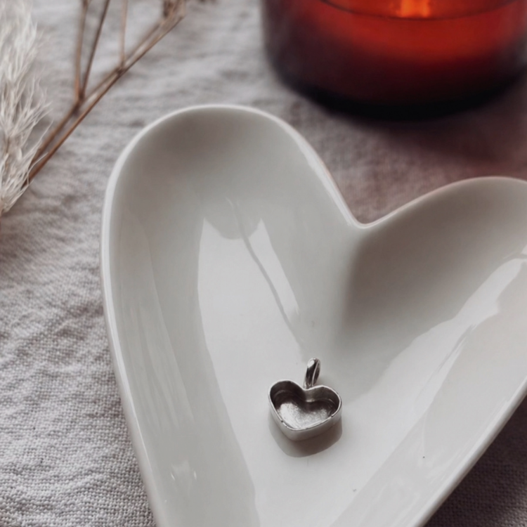 a heard shaped bowl, with a heart shaped necklace casing made of sterling silver