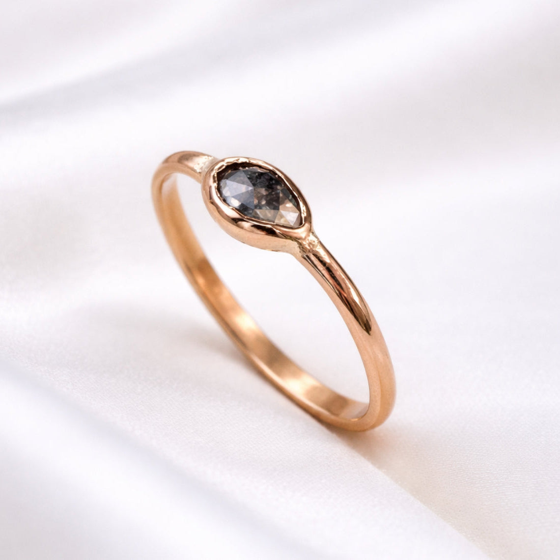 14k gold ring with a dark gemstone on a white background