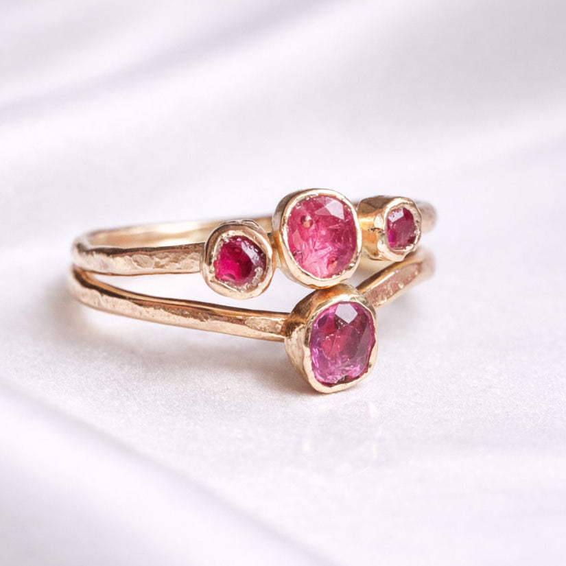 Gold ring with pink gemstones on a white background