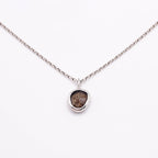 Necklace with a pendant featuring a rough diamond on a white background